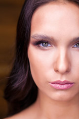 Obraz premium Brunette young woman. Studio portrait of calm girl looking in camera or at you