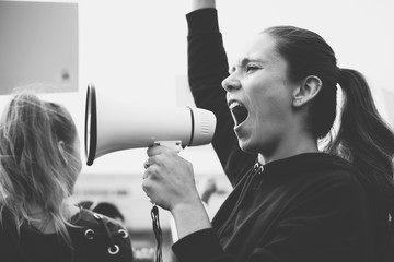 Female activist shouting on a megaphone - obrazy, fototapety, plakaty