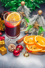 Hot wine (mulled wine) with spices on wooden background.