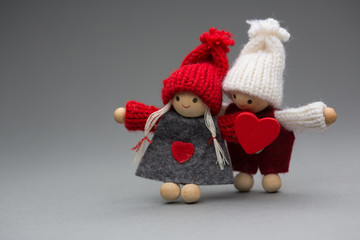 Two dolls in love on Valentines day knitted wear with heart postcard