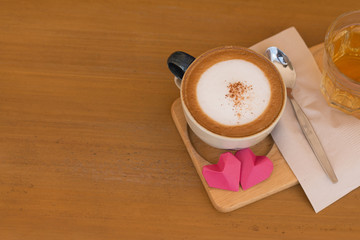 Valentines day concept, red paper hearts and a cup of coffee on a wooden desk background
