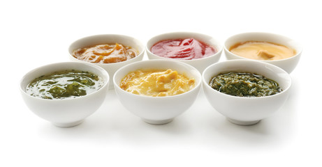 Different tasty sauces in bowls on white background