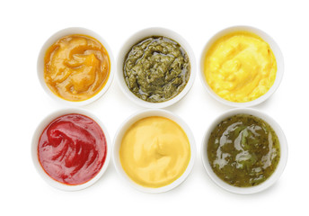 Different tasty sauces in bowls on white background