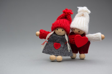 Two dolls in love on Valentines day knitted wear with heart postcard