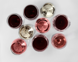 Glasses with different kinds of wine on white background, top view