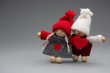 Two dolls in love on Valentines day knitted wear with heart postcard