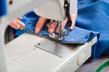 Sewing workshop. Sewing zipper on sewing machine.