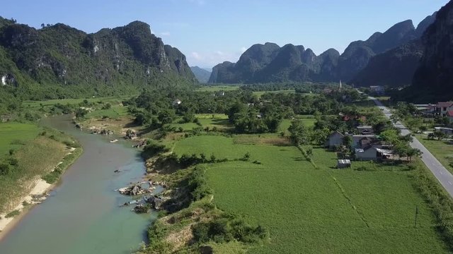aerial motion from river with boats to groves on fields