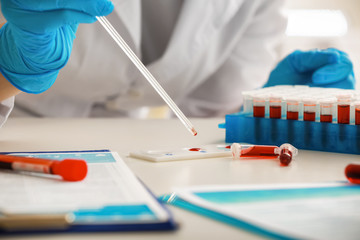 Woman working with blood sample in laboratory