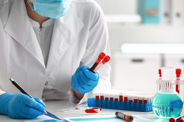 Woman working with blood samples in laboratory