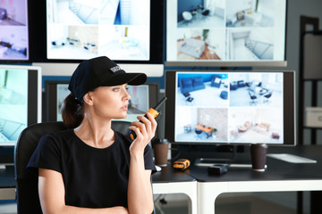Security guard with portable radio transmitter in surveillance room