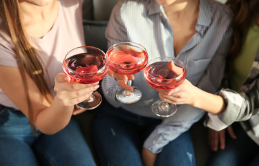 Beautiful young women drinking champagne at home