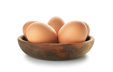 Raw chicken eggs in bowl on white background