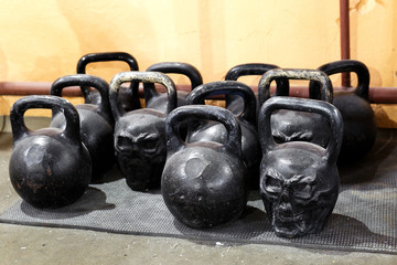 Fototapeta na wymiar Kettlebells for sports, athletics. Several black weights are on the floor on a rubber Mat