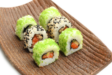 Plate with tasty sushi rolls on white background
