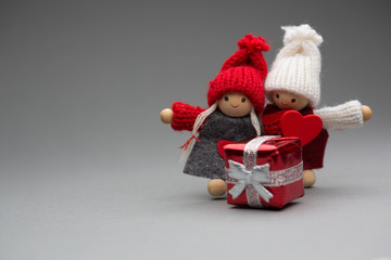 Two dolls in love on Valentines day knitted wear with heart postcard