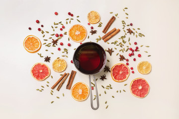 Pot of tasty mulled wine and ingredients on white background