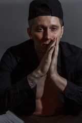 Portrait of determined goodlooking man wearing black shirt, black background.