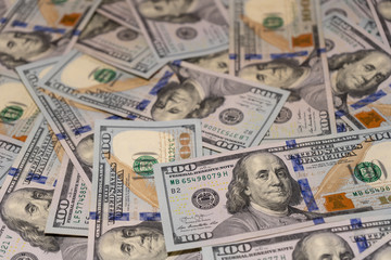 Fototapeta na wymiar Close-up of randomly scattered hundred dollar bills