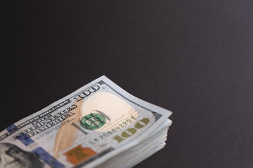 A big pack of hunred dollar bills on black background