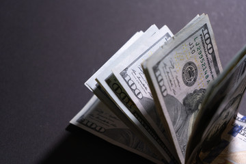 Close-up of hundred dollar bills on black background