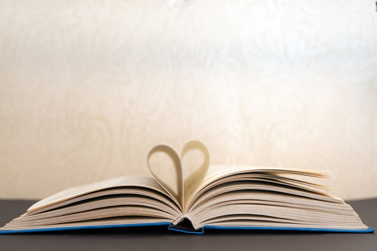 open book with heart shaped pages on a table