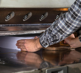 Front view of a paper guillotine in commercial printing industry. Hydraulic industrial guillotine.