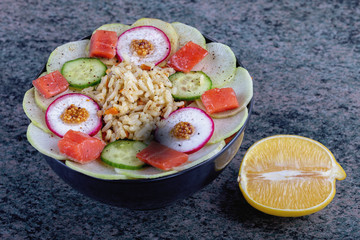 Poke bowl trand. Raw fish, rice and halhy vegetables on wooden background
