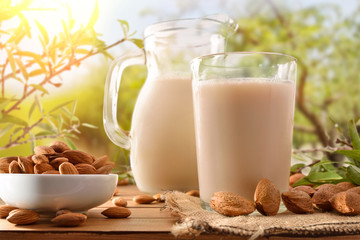 Almond drink on table with jug in the field detail
