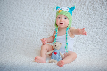 A child in a funny hat asks for a toy