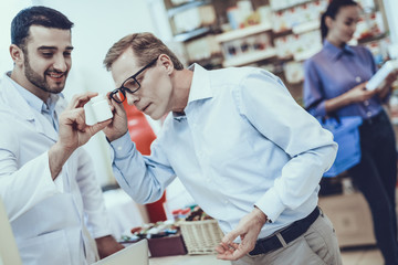 Man choose a medicaments in pharmacy