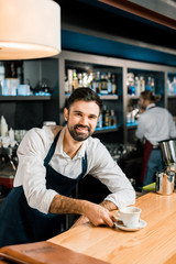 Fototapeta na wymiar cheerful smiling barista with coffee at wooden table
