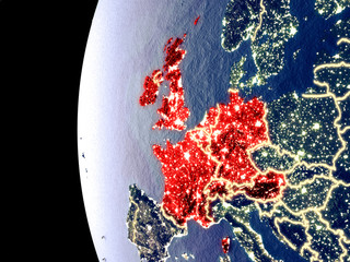 Night view of Western Europe from space with visible city lights. Very detailed plastic planet surface.