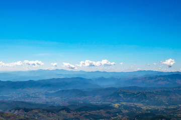 The mountains and forests with blue sky and white clouds at the peak of Inthanon national park (park name) in Chiang Mai province , Thailand in a sunny day. 