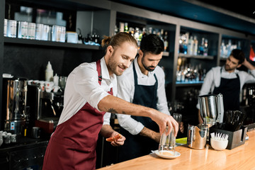smiling barman decorating glass with sugar while holding grapefruit slice