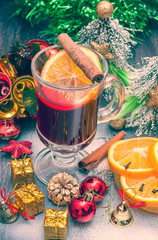 Hot wine (mulled wine) with spices on wooden background.