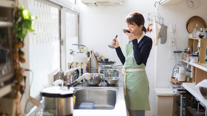 調理の味見をする主婦