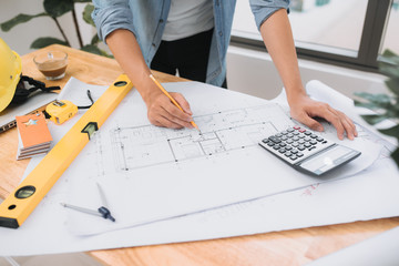 Architect designing on table in office, Vintage, Sunset light, Yellow safety hard hat