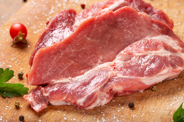 Slices of raw pork meat with herbs