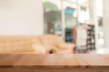 Wooden desk with Abstract blurred livingroom decoration interior for background