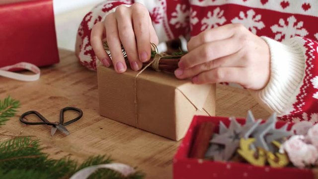 Girl's hands preparing christmas gifts at home