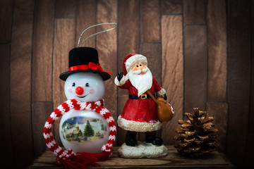 Snowman with Christmas decoratio on wooden background