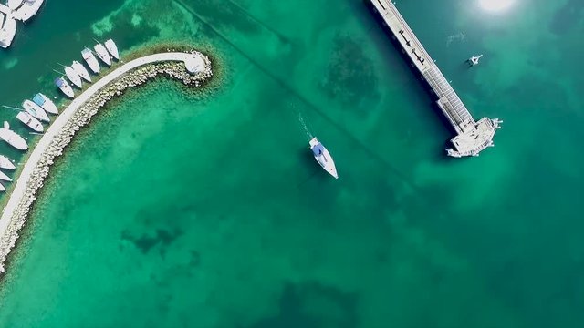 Prise de a&eacute;rienne au drone au dessus d'un port d'un lac. Vue au dessus d'un bateau. Belle eau. Port en bordure du lac L&eacute;man. Port situ&eacute; &agrave; Thonon-les-bains, France.