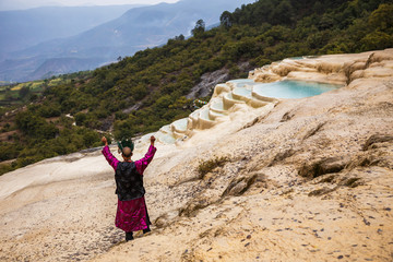 Shaman in national clothes and crown on his head, doing authentic ritual of summoning spirits at...