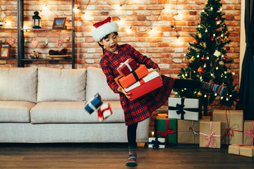 happy little girl holding many christmas gifts