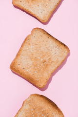 top view of row of delicious toasts on pink tabletop