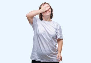 Young adult woman with down syndrome over isolated background smiling and laughing with hand on face covering eyes for surprise. Blind concept.