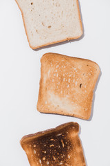top view of toasts in various roast stages on white surface