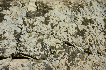 Mountain stone with a natural texture as a design concept. Cracks created by nature on the surface of the stone with a natural color scheme, create a natural textured background. Texture for design .