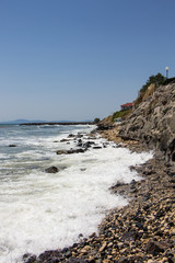 Fototapeta na wymiar Landscape of the sea and sea coast with rocks and blue sky. Sea waves crashing on the rocks. Black sea. Ravda. Bulgaria.